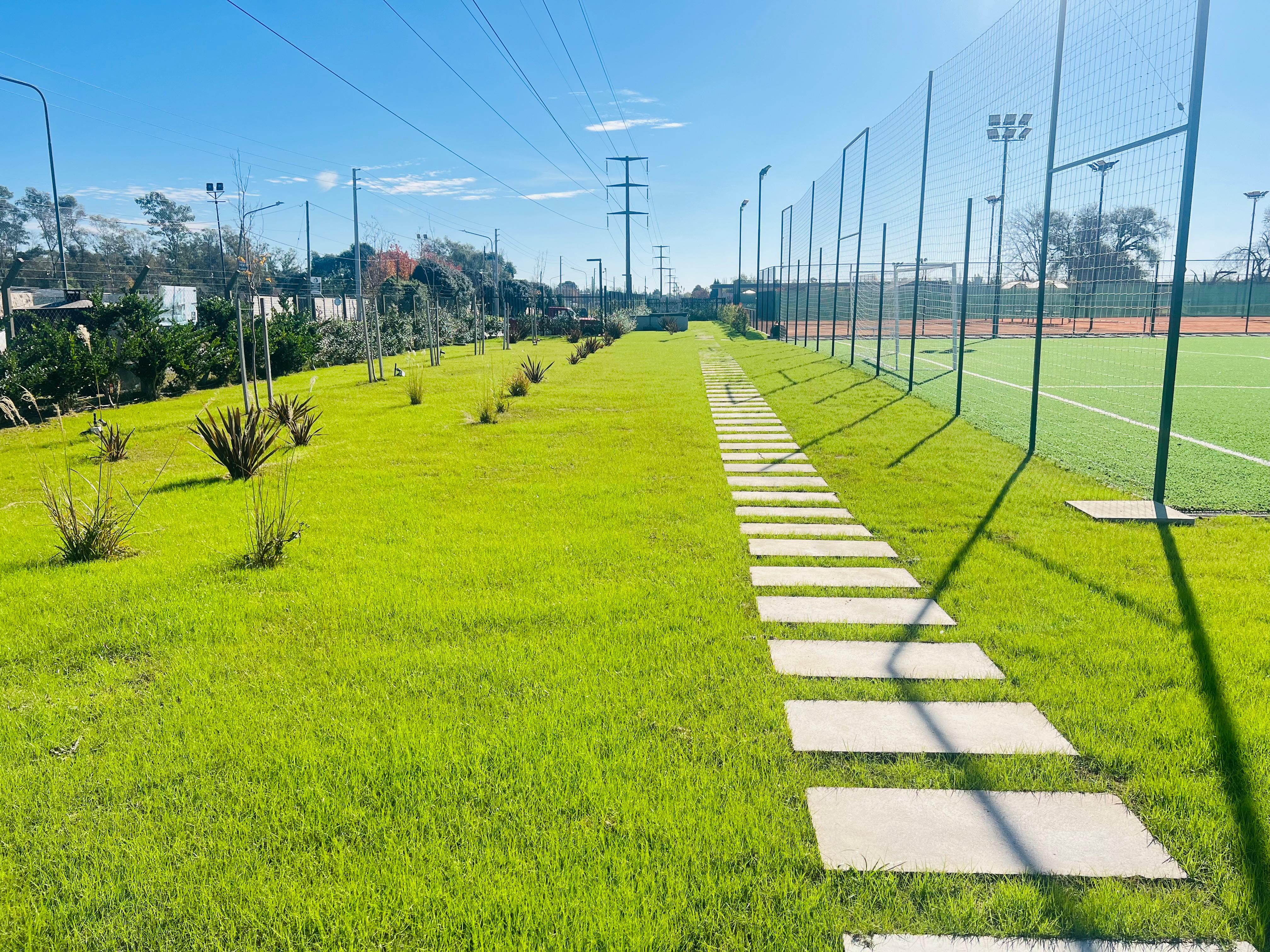 Sendero y cancha con césped impecable
